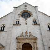 Per raggiungere l�ingresso camminiamo per qualche metro su via della Minerva raggiungendo la vicina piazza omonima. La bianca facciata di stile romanico pugliese presenta un grande rosone centrale sul quale campeggia la statua di Giuditta con la testa di Oloferne. Sotto, invece, una scultura di Ercole si batte con un mostro marino e un leone, simboli delle 12 fatiche